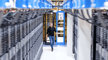 A confident man walking through a large data center can copy and integrate data at enterprise scale.